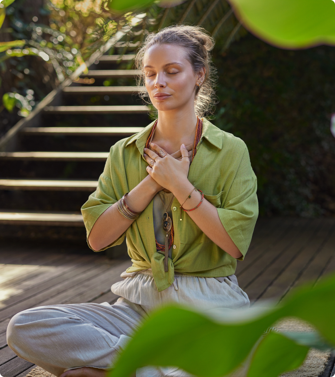 Woman meditating outdoors with eyes closed.